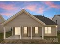 Back of house featuring a covered patio with white columns and a well-manicured lawn at 2236 Prairie Rd, Concord, NC 28027
