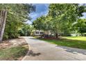 Long driveway leading to a charming house surrounded by lush greenery and mature trees at 2434 Olewoods Ct, Rock Hill, SC 29732
