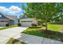 Beautiful home exterior featuring a well-manicured lawn, mature tree, and a spacious two-car garage at 258 Cherrytree Dr, Fort Mill, SC 29715