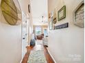 Inviting hallway with wood floors, decorative wall decor, and an open view into the living area at 2843 Startown Rd, Lincolnton, NC 28092