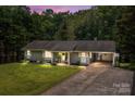 Serene evening view of a cozy single-story home with lush lawn, covered entry, and convenient carport at 312 Walton Dr, Statesville, NC 28625