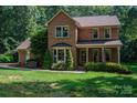 Lovely brick two-story home with lush green lawn and manicured landscaping and shrubs at 3513 Briarcliff Acres Dr, Lincolnton, NC 28092
