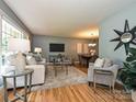 Bright living room featuring hardwood floors, neutral furniture, and a dining room view at 4000 Chandworth Rd, Charlotte, NC 28210