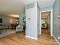 Open-concept living room with hardwood floors and blue-grey walls leads to dining and den at 4000 Chandworth Rd, Charlotte, NC 28210