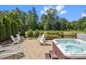 Relaxing backyard with a stone patio, hot tub, and white Adirondack chairs perfect for outdoor entertaining at 435 Galbreath Ct # 128, Fort Mill, SC 29708