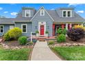 Charming blue two-story home boasts a beautifully landscaped front entrance and inviting red door at 509 N Oak St, Lincolnton, NC 28092