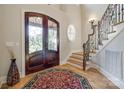 Foyer features wood floors, wrought iron staircase, wood-framed entry door, and decorative rug at 546 Little Cove Ln, Lake Wylie, SC 29710