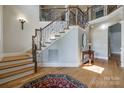 Spacious foyer with wood flooring, staircase with wrought iron railing, and decorative rug at 546 Little Cove Ln, Lake Wylie, SC 29710