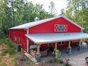 Unique red barn-style home featuring a hot tub on a covered patio at 574 Crescent Rd, Rockwell, NC 28138