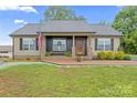 Charming single-story home with brick accents, a decorative front door, and an American flag at 632 Skyland N Dr, Mount Pleasant, NC 28124