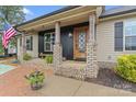Close-up of front porch with brick columns, decorative wood door and an American flag at 632 Skyland N Dr, Mount Pleasant, NC 28124