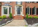 Inviting front entrance of a brick home with manicured garden and walkway at 6432 Morningsong Ln, Charlotte, NC 28269
