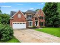 Traditional brick home featuring an attached garage and professionally landscaped lawn at 6432 Morningsong Ln, Charlotte, NC 28269