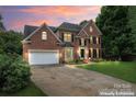 Gorgeous brick home with manicured lawn and inviting driveway, dusk view at 6432 Morningsong Ln, Charlotte, NC 28269