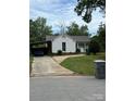 Charming white home with a covered carport and neatly landscaped lawn on a partially cloudy day at 6507 Chewink Ct, Charlotte, NC 28227