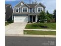This two story home features a two car garage and manicured front yard at 7024 Wheyfield Dr, Charlotte, NC 28215