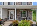 Inviting front porch with stone accents, a seating area, and beautifully landscaped garden beds at 7331 Millstone Sw Cir, Concord, NC 28025