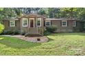 Welcoming home with well-manicured lawn, complemented by wood accents on the front porch at 8321 Walkup Rd, Waxhaw, NC 28173