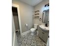 Stylish bathroom with patterned tile flooring, a modern vanity, and a closet at 410 Gann St, Lowell, NC 28098