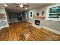 Bright living room with hardwood floors, a brick fireplace, and a view of the kitchen at 410 Gann St, Lowell, NC 28098