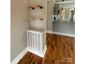 Open living space with hardwood floors, floating shelves, and white radiator at 410 Gann St, Lowell, NC 28098