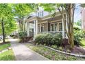 Attractive home with a spacious covered porch, brick detailing, and curb appeal in a tree-lined neighborhood at 7023 Blakeney Greens Blvd, Charlotte, NC 28277