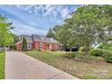 Spacious front yard featuring lush landscaping, mature trees, and a well-maintained lawn at 10024 Tealridge Ln, Charlotte, NC 28277