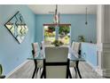 Bright dining room featuring light blue walls, and a table overlooking the landscaped backyard at 1017 Quail Run Ct, Indian Land, SC 29707