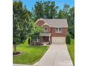 Lovely two-story brick home with a well-maintained lawn and long driveway, surrounded by mature trees offering curb appeal at 1017 Quail Run Ct, Indian Land, SC 29707