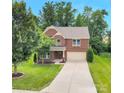 Inviting two-story brick home with a well-kept lawn, mature trees, and a spacious driveway leading to the garage at 1017 Quail Run Ct, Indian Land, SC 29707