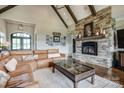 Inviting living room features a stone fireplace, beamed ceiling, and comfortable leather sectional at 109 Oak Forest Dr, Kings Mountain, NC 28086