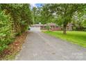 Long driveway leads to a brick home with a two-car garage and lush green lawn at 121 33Rd Ne Ave, Hickory, NC 28601