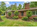 Charming brick home features a cozy front porch and lush landscaping around the entrance at 121 33Rd Ne Ave, Hickory, NC 28601