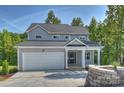 Inviting gray two-story home with an attached garage, covered entrance and freshly poured driveway at 126 Meadow Glen Dr, Troutman, NC 28166
