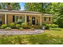Inviting brick home featuring a cozy front porch and lush landscaping at 141 Dunlap Loop, Statesville, NC 28625