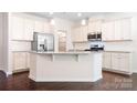 Bright kitchen boasts white cabinets, stainless steel appliances, and a granite island at 14611 Murfield Ct, Charlotte, NC 28278