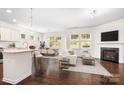 Open-concept living space featuring a modern fireplace, hardwood floors, and bar seating at the kitchen island at 14611 Murfield Ct, Charlotte, NC 28278