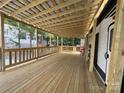 This back porch features wooden flooring and a ceiling with an attached white camper at 152 Eagle Dr # 27B, New London, NC 28127