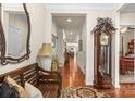 Inviting hallway with hardwood floors, a grandfather clock, and decorative mirror at 163 Carmen Way, Lancaster, SC 29720