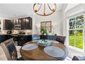 Cozy dining area with a wood table, modern lighting, and a view into the kitchen, perfect for Gathering meals at 1644 Backcreek Ln, Gastonia, NC 28054