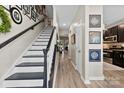 Inviting entryway with a staircase, light wood floors, and decorative wall art leading into the home's living spaces at 1644 Backcreek Ln, Gastonia, NC 28054