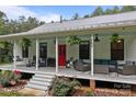 Cozy front porch with ample seating, hanging ferns, and stylish decor for relaxing and entertaining at 213 Genesis Pl, Cleveland, NC 27013