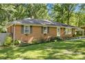 Side view of a charming brick home with green shutters and a well-maintained lawn at 2522 Doster Rd, Monroe, NC 28112
