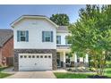 Charming two-story home with a two-car garage, stone accents, blue shutters, and manicured landscaping at 2844 Georgia Ave, Charlotte, NC 28205