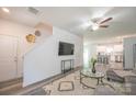 Inviting living room featuring modern decor, a ceiling fan, gray wood flooring, and seamless access to the kitchen at 3403 Keith Dr, Charlotte, NC 28269