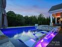 Inviting pool with in-water loungers and a tranquil backyard setting with lush greenery at 4049 Shadowbrook Rd, Waxhaw, NC 28173