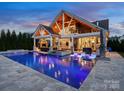 Stunning outdoor space with a pool, lounge chairs, outdoor kitchen, and spiral staircase under vaulted ceilings at 4049 Shadowbrook Rd, Waxhaw, NC 28173