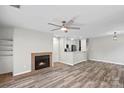 Cozy living room featuring a brick fireplace and wood flooring, complemented by an open kitchen layout at 409 W 8Th St, Charlotte, NC 28202