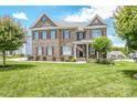 Charming brick home featuring a manicured lawn, tasteful landscaping, and a welcoming front porch at 424 Cassia Ct, Fort Mill, SC 29708