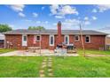 Brick home's backyard with a patio, mature trees, and a brick chimney at 4527 Marshall Ct, Monroe, NC 28110